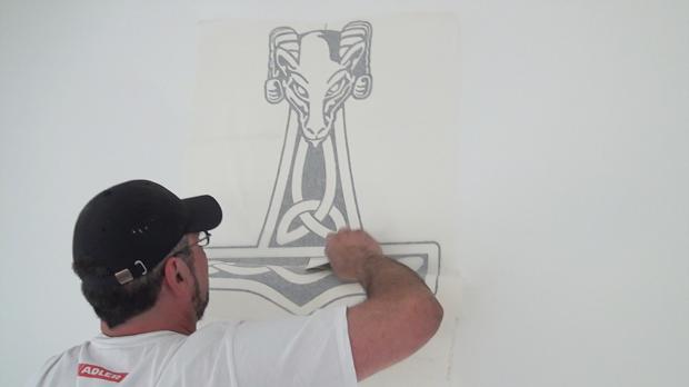 Wandtattoo mit dem Spachtel an die Wand reiben