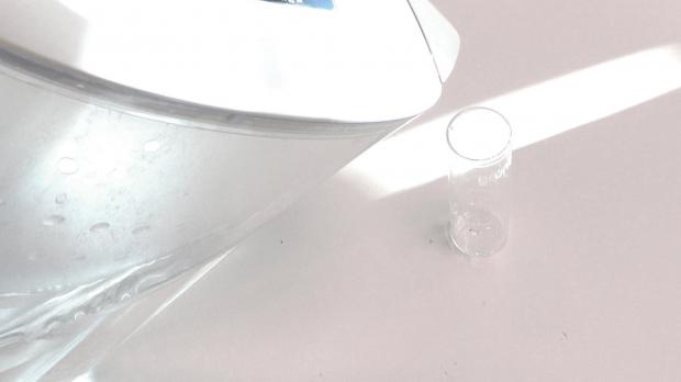 Gefiltertes Wasser in Messbecher füllen